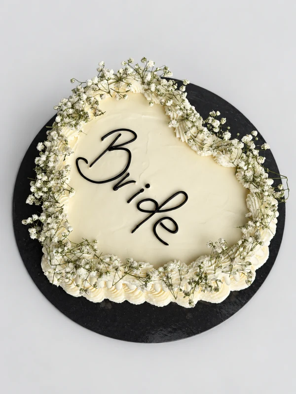 Торт "Bride" — Торт «Bride» — белый торт-сердце с надписью Bride и нежным цветочным обрамлением.